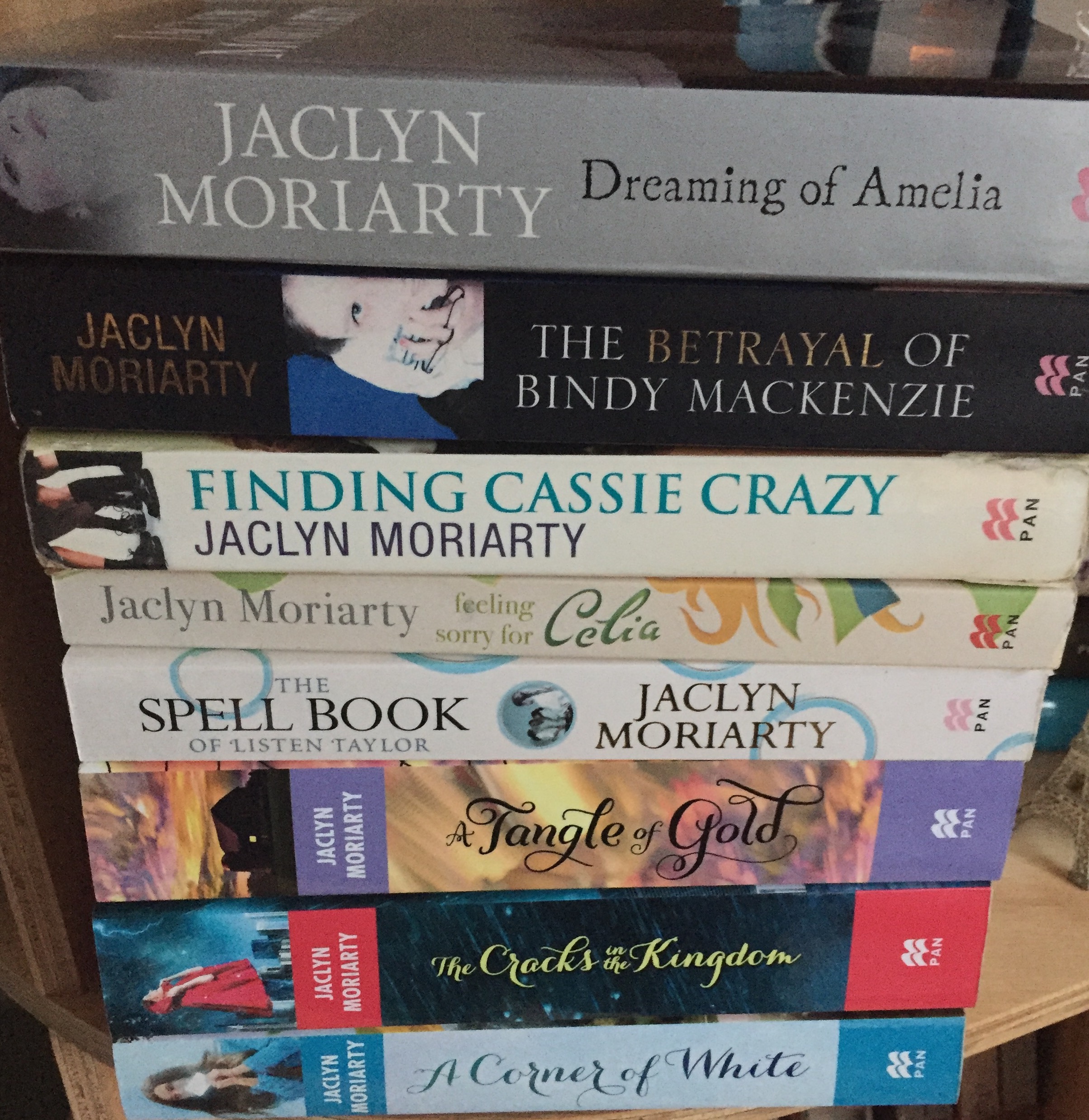 Stack of Jaclyn Moriarty books: Dreaming of Amelia, The Betrayal of Bindi Mackenzie, Finding Cassie Crazy, Feeling Sorry for Celia, The Spell Book of Listen Taylor, A Tangle of Gold, The Cracks in the Kingdom, a Corner of White